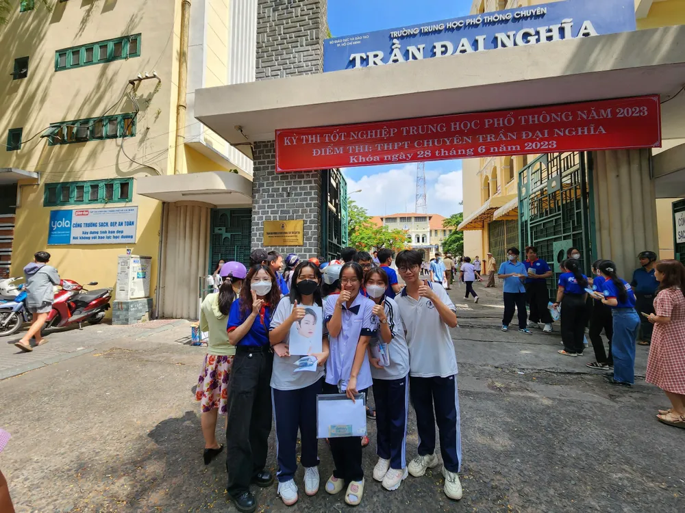 Khánh Dung - con gái cô Chi (nữ sinh đeo khẩu trang màu đen) hạnh phúc khi được mẹ đến đón cùng với tấm ảnh của thần tượng. Ảnh: NVCC