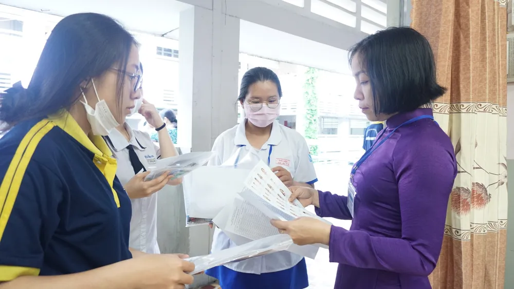 Giám thị kiểm tra giấy tờ của thí sinh tại điểm thi Trường THPT Gò Vấp, quận Gò Vấp. Ảnh: NGUYỄN QUYÊN