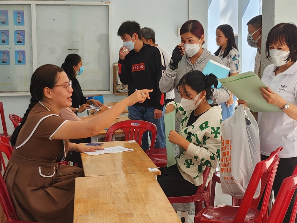 Phụ huynh đến làm hồ sơ nhập học vào lớp 10 tại Trường THPT Võ Trường Toản, quận 12. Ảnh: NGUYỄN QUYÊN