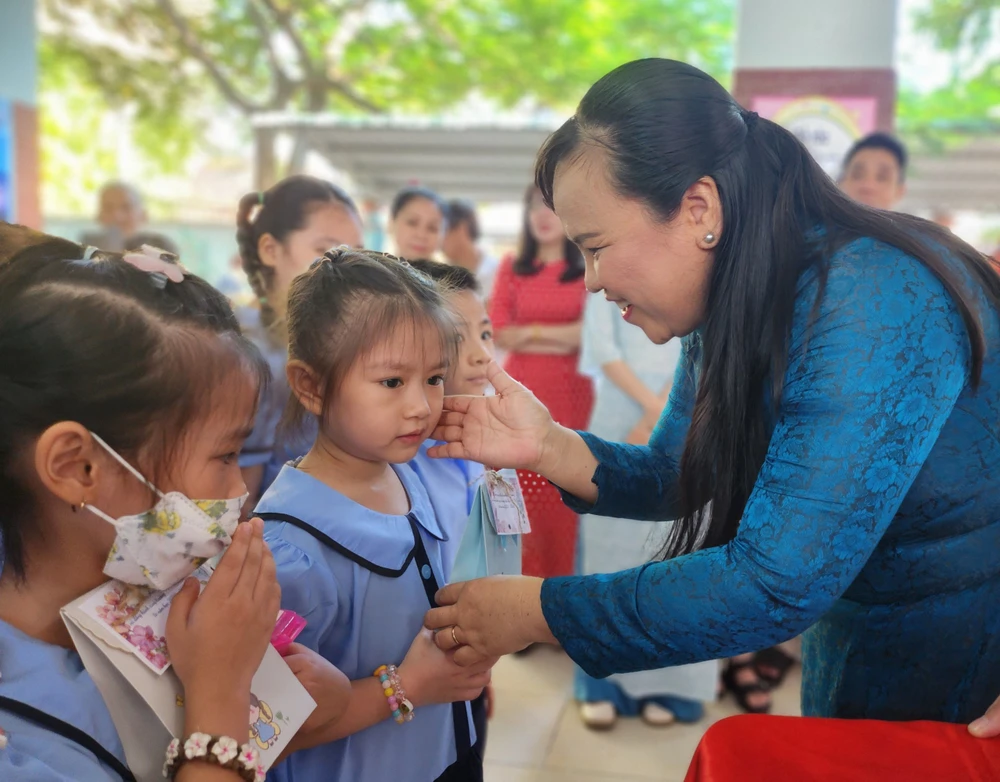 Bà Đỗ Thị Mỹ Hoà, Hiệu trưởng nhà trường tặng quà cho các em. Ảnh: NGUYỄN QUYÊN