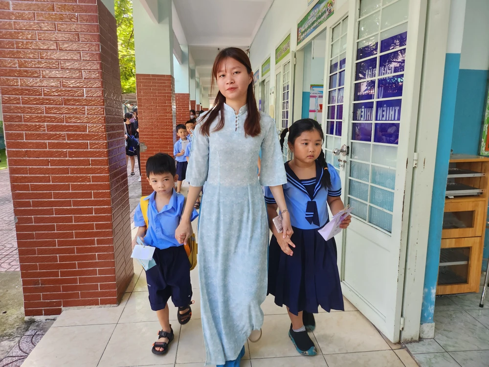 Giáo viên Trường Tiểu học Triệu Thị Trinh, quận 10 dẫn học sinh tham quan các phòng học. Ảnh: NGUYỄN QUYÊN