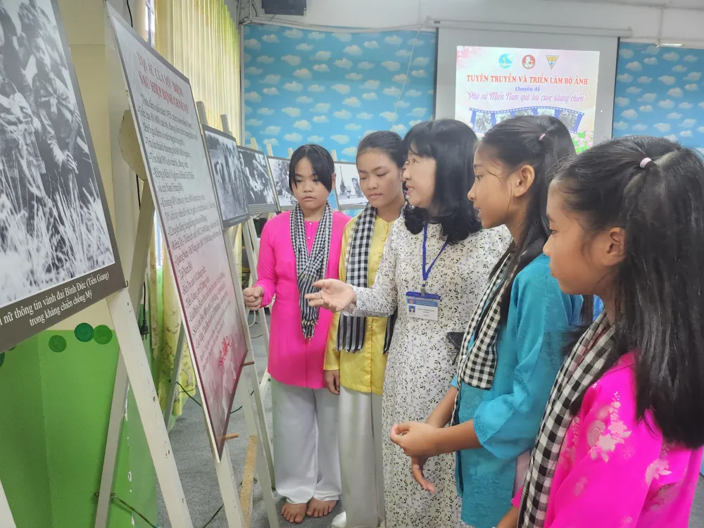 Cô trò thích thú khi tham quan triển lãm ảnh "Phụ nữ miền Nam qua hai cuộc kháng chiến" tại thư viện của trường. Ảnh: NGUYỄN QUYÊN z4831807170535_db55c2ab073b96e62c698f0262124945.jpg