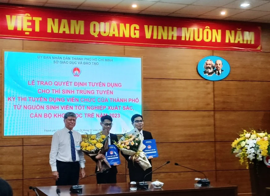 Ông Nguyễn Văn Hiếu, Giám đốc Sở GD&ĐT TP.HCM trao quyết định phân công nhiệm sở cho các ứng viên trúng tuyển kỳ tuyển dụng viên chức của TP.HCM vừa qua. Ảnh: TT Hai sinh viên xuất sắc trúng tuyển viên chức về dạy tại trường chuyên