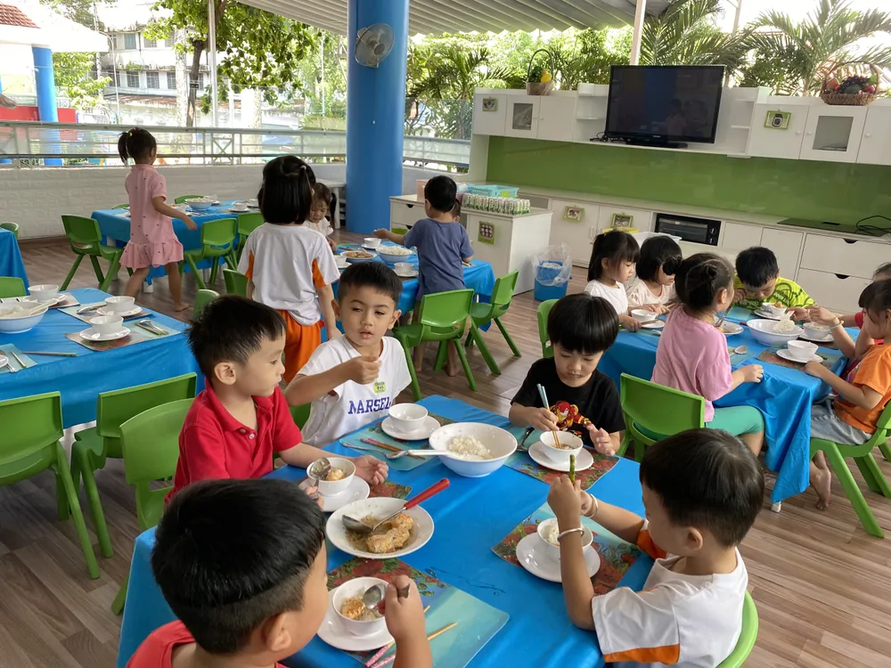 Trường Mầm non Vàng Anh đang lấy ý kiến phụ huynh về việc tăng tiền học để thực hiện mô hình trường tự chủ tài chính. Giờ ăn của các bé Trường Mầm non Vàng Anh, quận 5. Ảnh: WEBSITE TRƯỜNG tăng tiền học