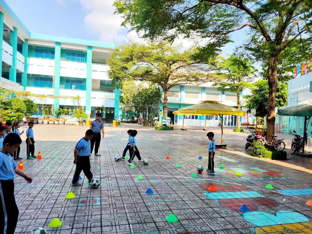 Trong tình hình nắng nóng kéo dài, giờ học thể dục của Trường Tiểu học Lê Văn Thọ, quận Gò Vấp được tổ chức dưới bóng râm, vào sáng sớm. Ảnh: NGUYỄN QUYÊN nắng nóng kéo dài