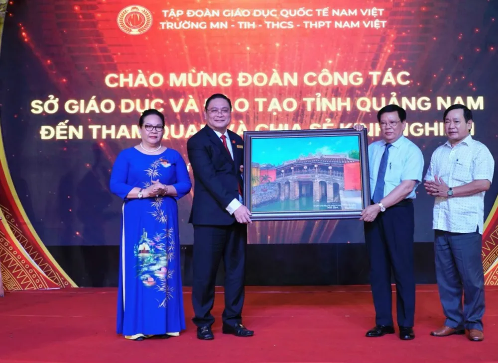 Ông Thái Viết Tường, Giám đốc Sở GD&ĐT Quảng Nam (thứ 2 từ phải qua) tặng bức tranh Chùa Cầu cho lãnh đạo Trường mầm non, tiểu học, THCS, THPT Nam Việt. Ảnh: NTCC Sở GD&ĐT Quảng Nam