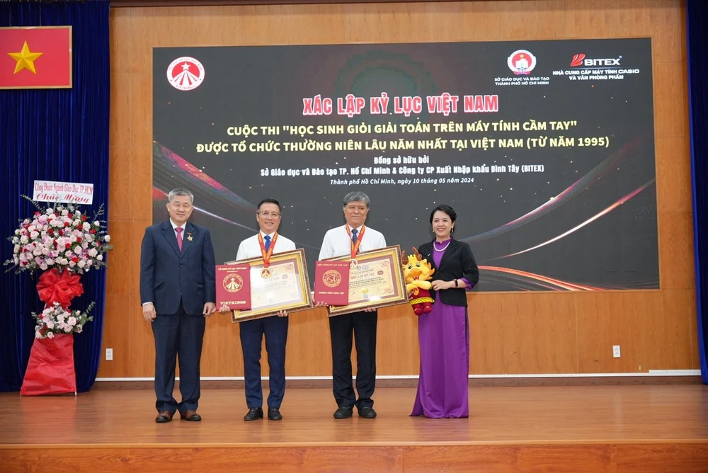 Ông Nguyễn Văn Hiếu, Giám đốc Sở GD&ĐT TP.HCM, (thứ 2 từ phải qua) và ông Nguyễn Xuân Dũng, Chủ tịch Hội đồng Quản trị Công ty BITEX, đón nhận kỷ lục "Kỳ thi học sinh giỏi giải toán trên máy tính cầm tay thường niên lâu năm nhất tại Việt Nam": Ảnh: BTC CUNG CẤP kỳ thi học sinh giỏi giải toán trên máy tính cầm tay