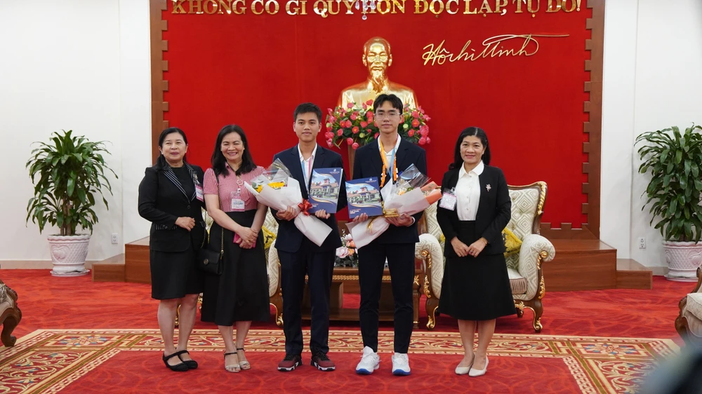 Ban lãnh đạo Trường THPT chuyên Lê Hồng Phong chụp hình cùng hai nam sinh đạt giải. Ảnh: HOÀNG QUÂN z5462673831316_e6c52d5802f9b993a32c85b9fd0bd2b4.jpg