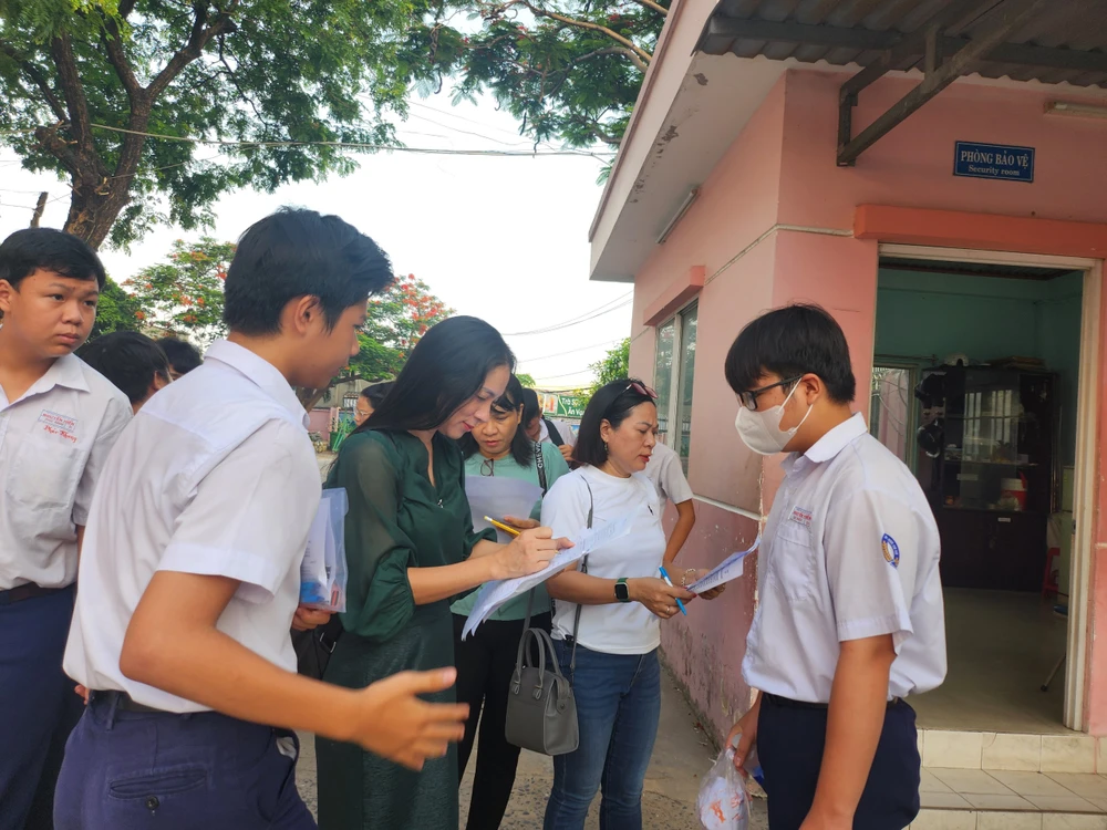 Giáo viên Trường THCS Nguyễn Hiền, quận 12 có mặt tại điểm thi từ sớm để điểm danh học trò đến dự thi. Ảnh: NGUYỄN QUYÊN thi-vao-lop-10-4.jpg