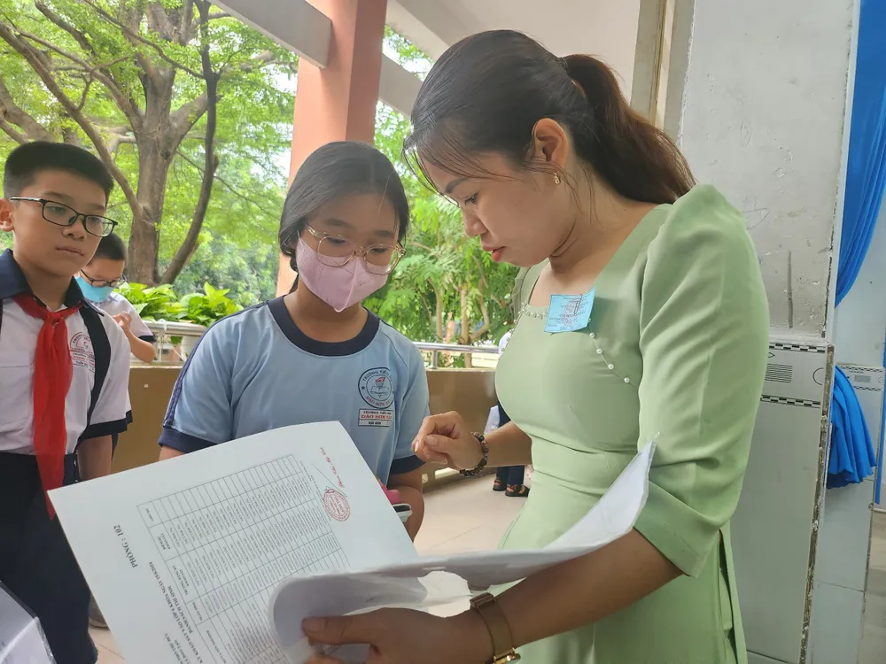 Giám thị kiểm tra giấy tờ của thí sinh trước khi vào phòng khảo sát. khao-sat-vao-lop-6-10-13.jpg
