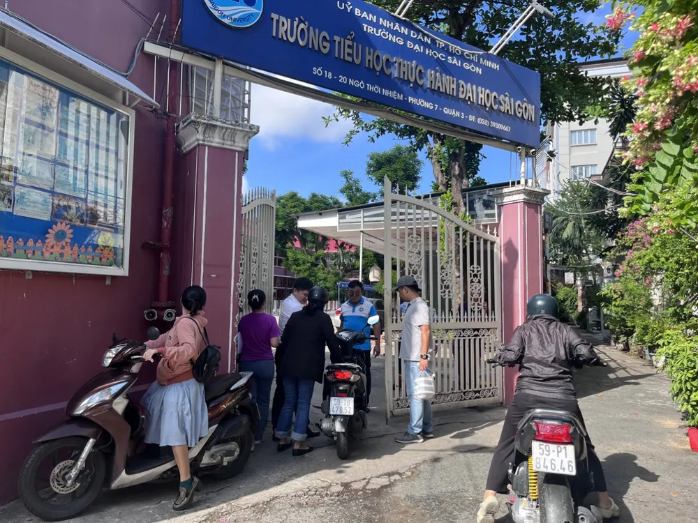 Năm nay chỉ tiêu vào lớp 1 của Trường Tiểu học Thực hành Đại học Sài Gòn giảm so với năm ngoái. Trong ảnh, phụ huynh đến trường chờ mua hồ sơ vào lớp 1 cho con. Ảnh: NHÀN LÊ mua-ho-so-vao-lop-1-2.jpg