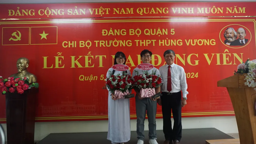 Giám đốc Sở GD&ĐT TP.HCM Nguyễn Văn Hiếu tặng hoa cho 2 đảng viên trẻ. truong-thpt-hung-vuong.JPG