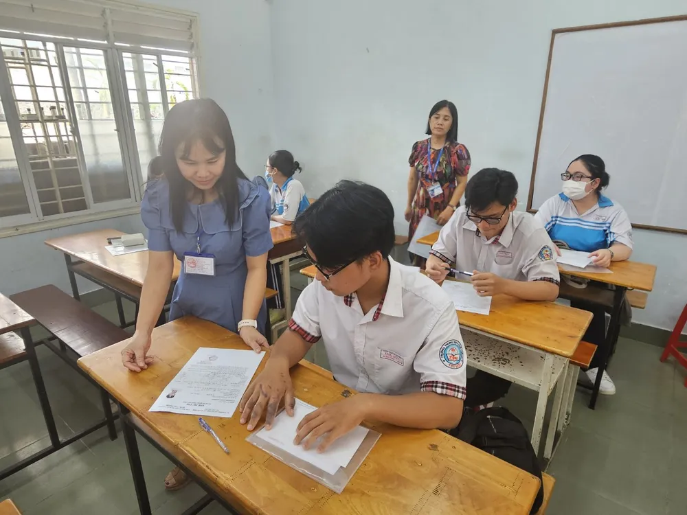 Phó Trưởng điểm thi Trường THPT Thủ Đức thăm hỏi sức khỏe của thí sinh bị bỏng. Ảnh: V.D thi tốt nghiệp THPT