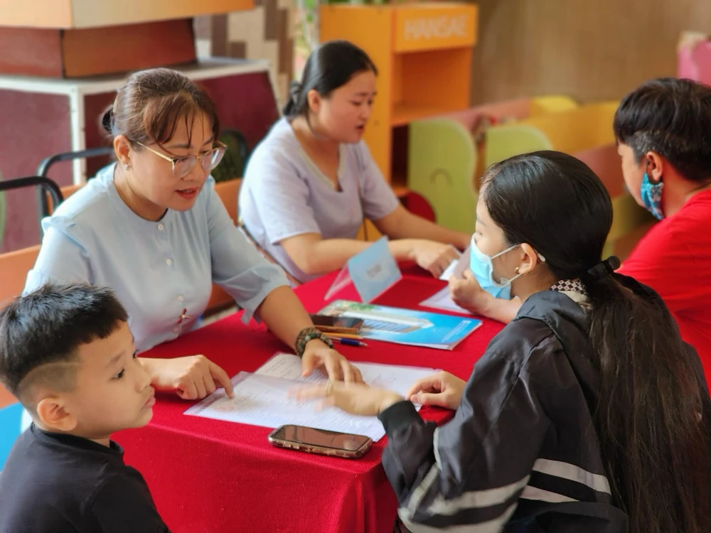 Bà Phạm Thúy Hà, Hiệu trưởng Trường Tiểu học Đặng Trần Côn, quận 4 tư vấn cho phụ huynh trong quá trình làm hồ sơ nhập học. Ảnh: NTCC tuyển sinh lớp 1