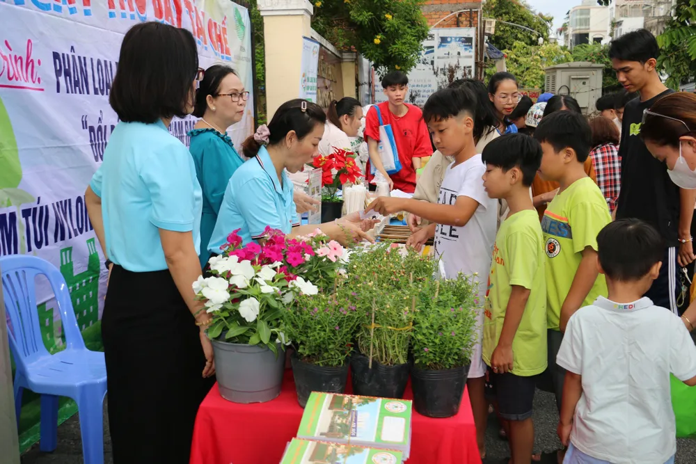 Các em lựa chọn đồ dùng học tập sau khi đã thu gom rác đến đổi tại phiên chợ xanh. Ảnh: HX doi-rac-lay-qua-2.jpg
