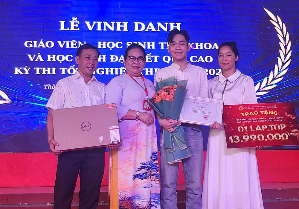 Em Lê Quốc Thịnh - thủ khoa khối C TP.HCM chụp hình cùng với bà Phan Thị Ánh Hoàng, Hiệu trường nhà trường và cha mẹ của mình. Ảnh: NQ thu-khoa-khoi-c-5.jpg