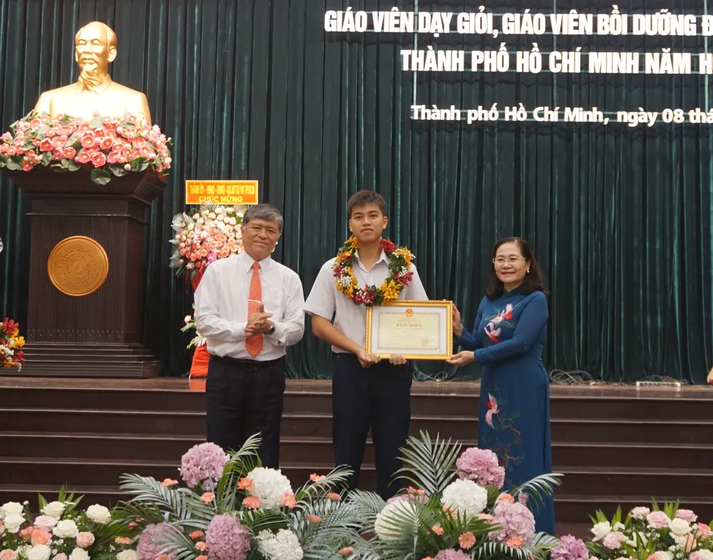 Bà Nguyễn Thị Lệ, Phó Bí thư Thành uỷ TP.HCM và ông Nguyễn Văn Hiếu, Giám đốc Sở GD&ĐT TP.HCM trao bằng khen cho em Lê Tuấn Hy, học sinh Trường THPT chuyên Lê Hồng Phong. Ảnh: NGUYỄN QUYÊN DSC06489.jpg
