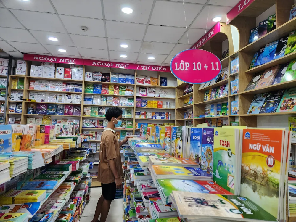 Học sinh tìm mua sách giáo khoa tại một nhà sách. Ảnh: NGUYỄN QUYÊN sách giáo khoa