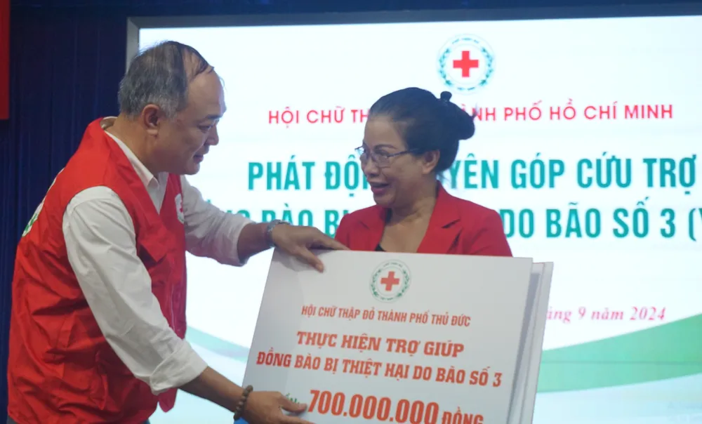 Bà Đặng Thị Minh Hiếu, Phó Chủ tịch Hội Chữ thập đỏ TP.HCM, tiếp nhận bảng tượng trưng đăng ký ban đầu hỗ trợ đồng bào lũ lụt của Hội Chữ thập đỏ TP Thủ Đức. Ảnh: NGUYỄN QUYÊN Hội Chữ thập đỏ TP.HCM