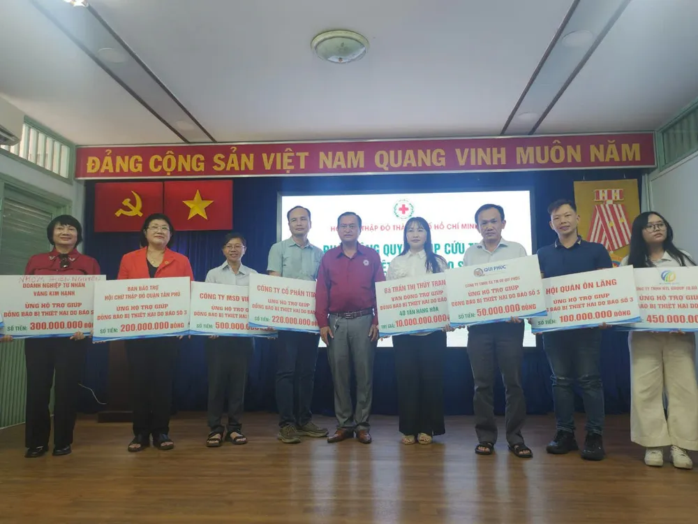Ông Trần Trường Sơn, Chủ tịch Hội Chữ thập đỏ TP.HCM, tiếp nhận bảng tượng trưng ủng hộ của các doanh nghiệp đối với đồng bào vùng lũ lụt. Ảnh: NGUYỄN QUYÊN z5836611204129_577b1d8bfb28abea0f1c75ce95b728f5.jpg