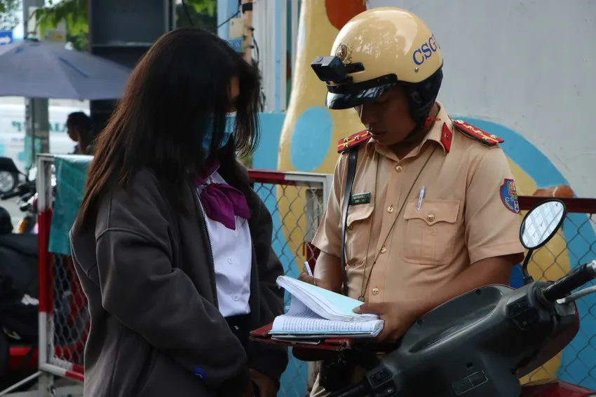 CSGT lập biên bản học sinh đi xe máy khi chưa đủ điều kiện lái xe. Ảnh: TỰ SANG vi phạm luật giao thông đường bộ