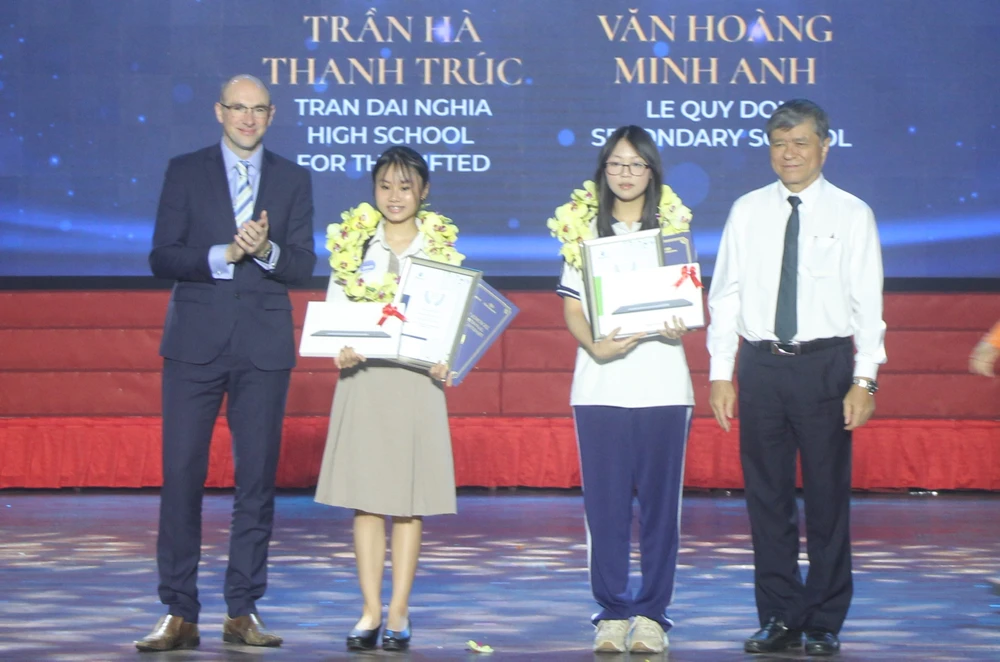 Ông Nguyễn Văn Hiếu, Giám đốc Sở GD&ĐT TP.HCM (bìa phải) cùng ông David Albon, Giám đốc phụ trách chương trình quốc tế, Tập đoàn giáo dục Pearson khen thưởng cho em Văn Hoàng Minh Anh đạt điểm Toán cao nhất thế giới và em Trần Hà Thanh Trúc đạt điểm tuyệt đối ở cả 3 môn. Ảnh: BTC diem-toan-cao-nhat-the-gioi-3.jpg