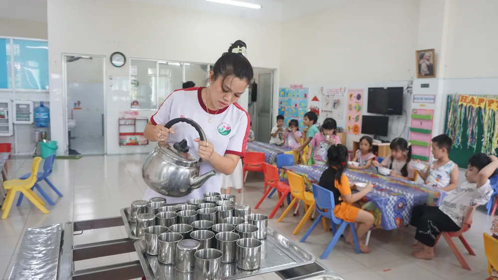 Cô giáo Trường Mầm non Hạnh Thông Tây, quận Gò Vấp rót sữa vào ly để trẻ dùng sau bữa ăn xế. Ảnh: NGUYỄN QUYÊN Lựa chọn sữa trong trường mầm non