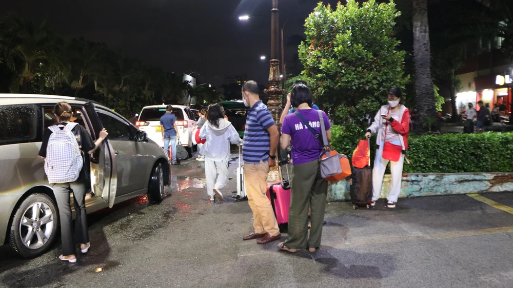 Một số hành khách đón xe taxi công nghệ để về nhà. Ảnh: HUỲNH THƠ