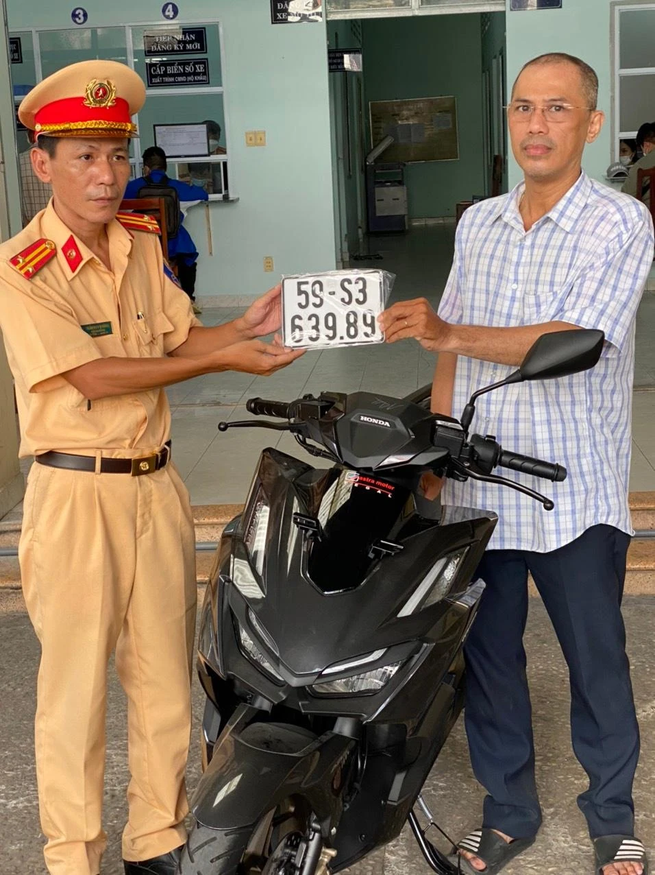 Người dân đầu tiên được trao biển số xe tại Công an quận Bình Thạnh.