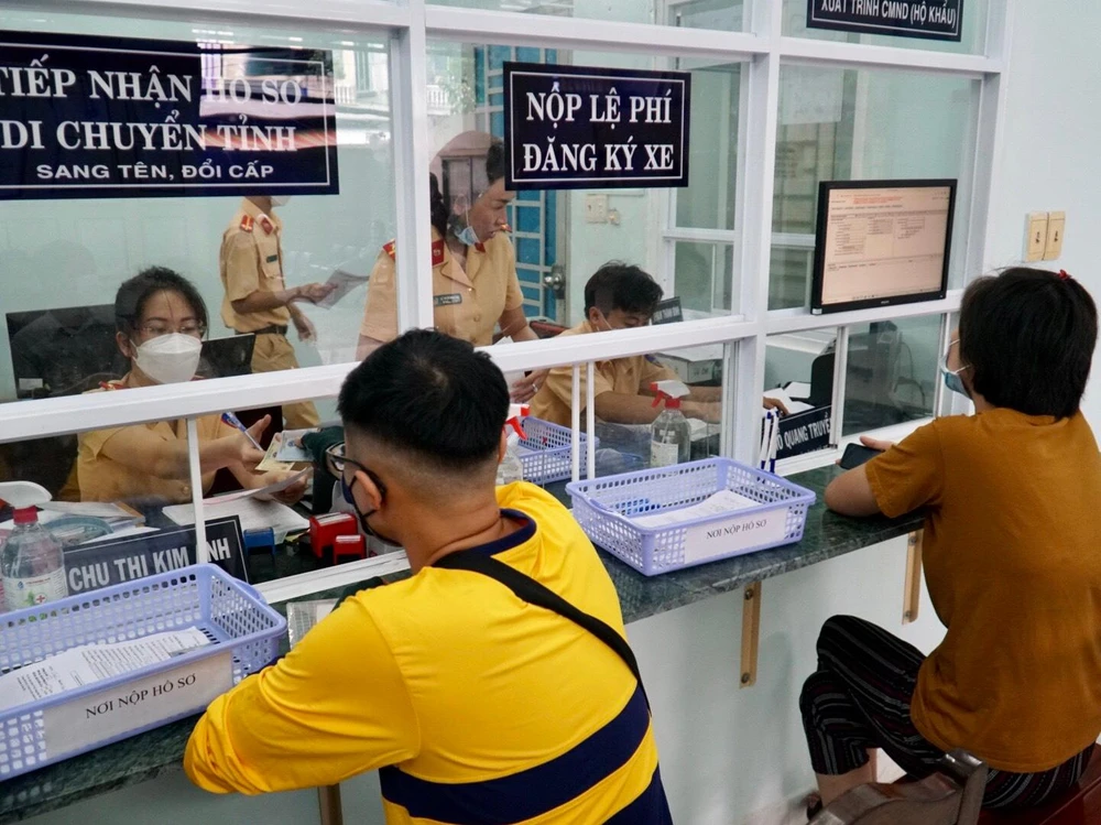 Các cán bộ đội đăng ký xe thuộc Công an quận Bình Thạnh đang thực hiện các quy trình đăng ký xe cho người dân.