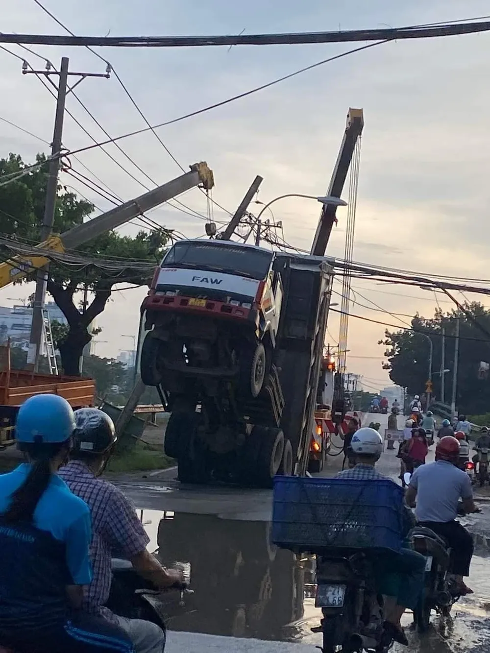 Nguyên nhân do thùng xe ben vẫn còn đang nâng nên vướng vào bó cáp viễn thông. Ảnh: NGUYỄN YÊN Nguyên nhân do thùng xe ben vẫn còn đang nâng nên vướng vào bó cáp viễn thông. Ảnh: NGUYỄN YÊN