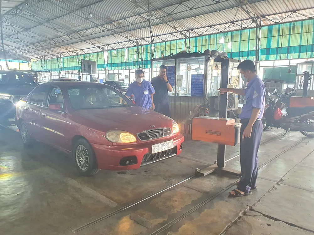 Các đăng kiểm viên kiểm tra hệ thống đèn xe. Ảnh: THY NHUNG Các đăng kiểm viên kiểm tra hệ thống đèn xe. Ảnh: THY NHUNG