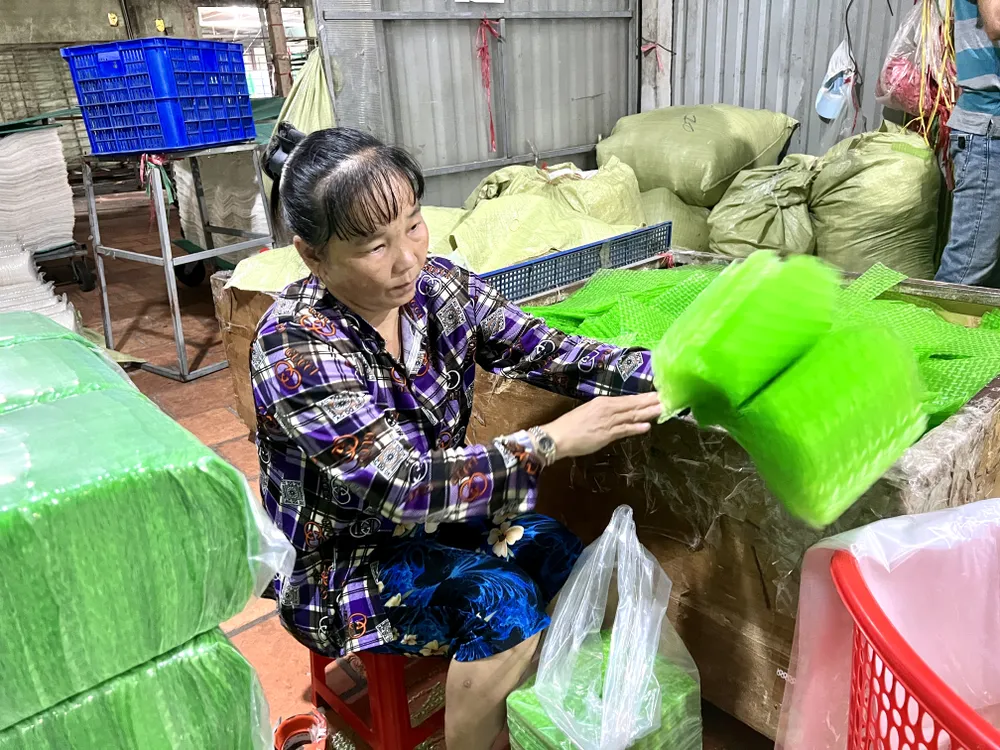 Các nhân viên đang kiểm tra để loại bỏ bánh tráng bị vỡ. Ảnh: THY NHUNG lang-nghe-banh-trang