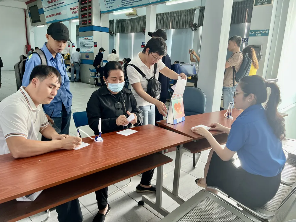 Ngành đường sắt bố trí nhân viên hướng dẫn người dân phiếu điền thông tin. Ảnh: TN ve-tau-tet