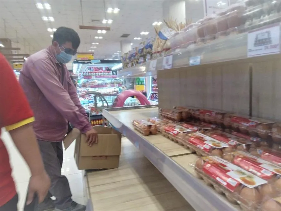 Một khách hàng thấy nhân viên xếp trứng lên kệ đã ra đòi mua cả thùng . ẢNH: TÚ UYÊN