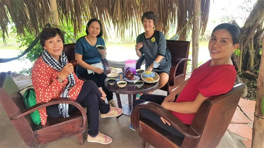 Nhiều người thưởng thức món sâm nước cốt dừa mát lành từ những lá sâm trồng quanh vườn ở homestay cô Vân (Cồn Chim).