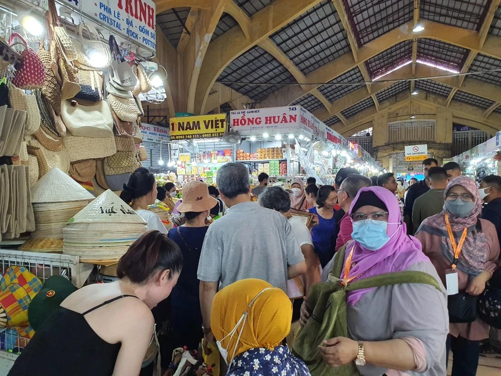 Du khách thích thú với các sản phẩm nón lá, túi xách...