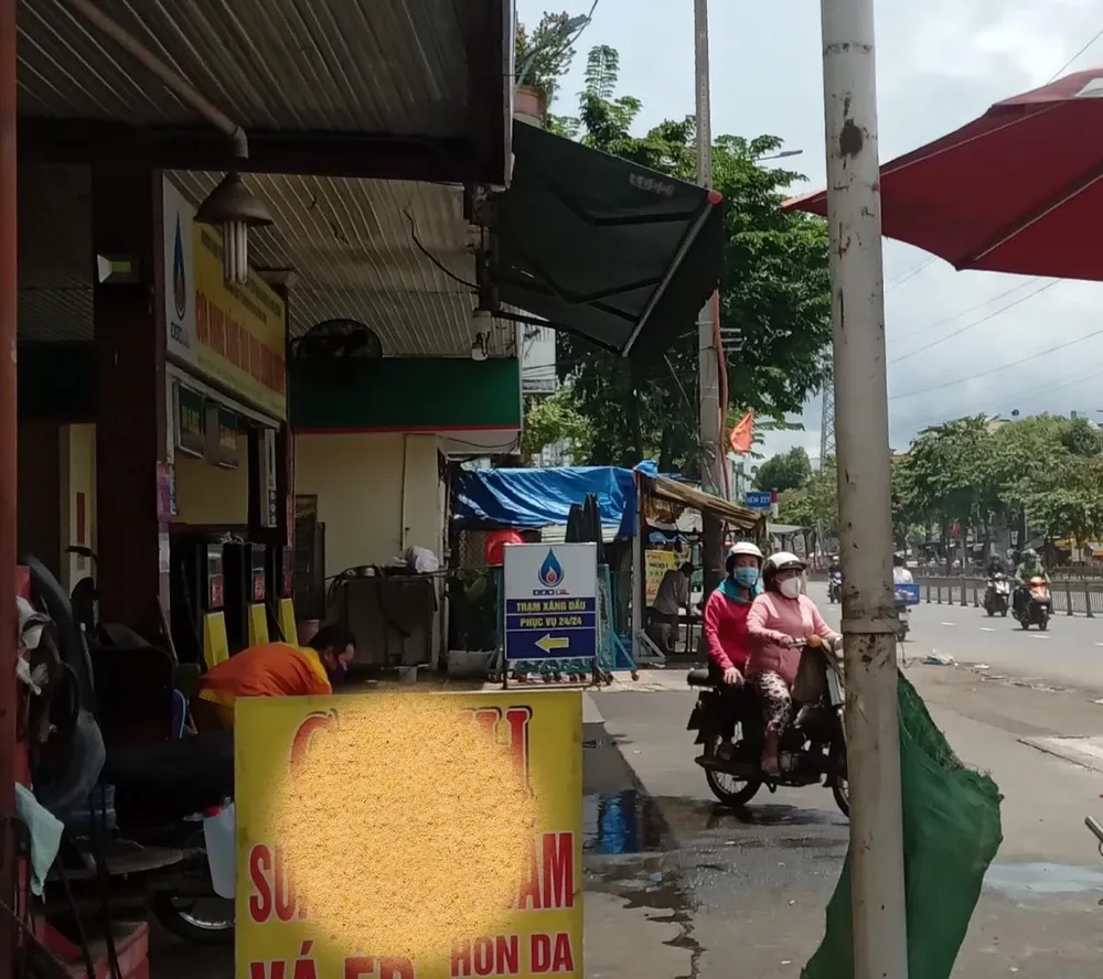 Cửa hàng xăng ở quận Bình Tân có nhân viên vẫy tay báo hiệu &quot;hết xăng&quot; cho khách. Ảnh: TÚ UYÊN