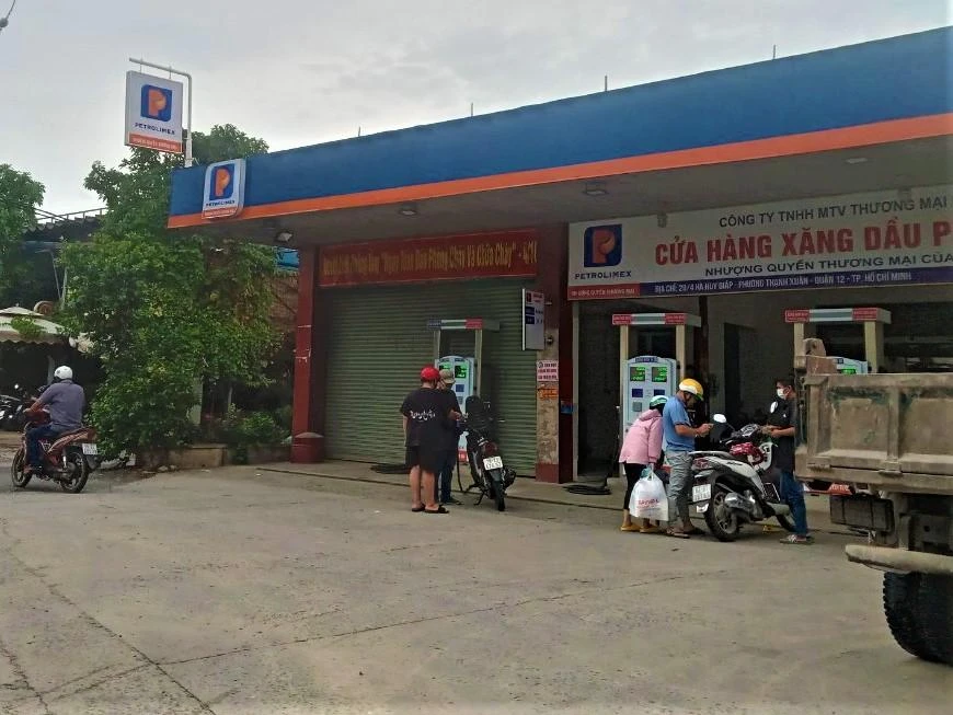 Người dân đổ xăng tại một cửa hàng quận 12. Ảnh: TÚ UYÊN Người dân đổ xăng tại một cửa hàng quận 12. Ảnh: TÚ UYÊN