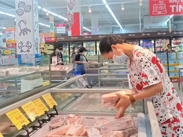 Người tiêu dùng chọn thịt heo đông lạnh bán tại siêu thị. ẢNH: TÚ UYÊN Người tiêu dùng chọn thịt heo đông lạnh bán tại siêu thị. ẢNH: TÚ UYÊN