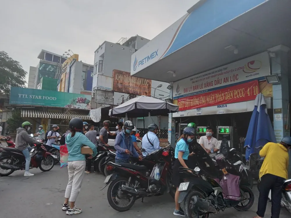 Nhiều người dân xếp hàng chờ đổ xăng tại một cửa hàng ở quận 12 trong chiều 7-10. Ảnh: TÚ UYÊN