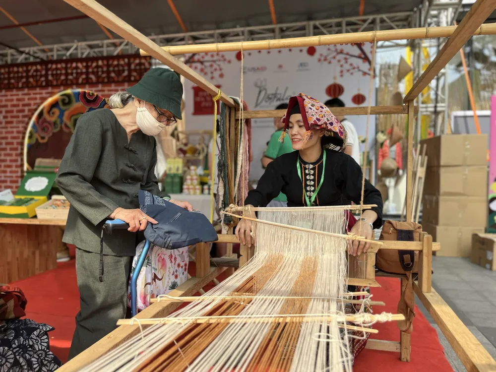 Khách tham quan tìm hiểu cách dệt ra các sản phẩm thủ công của những cô gái Thái