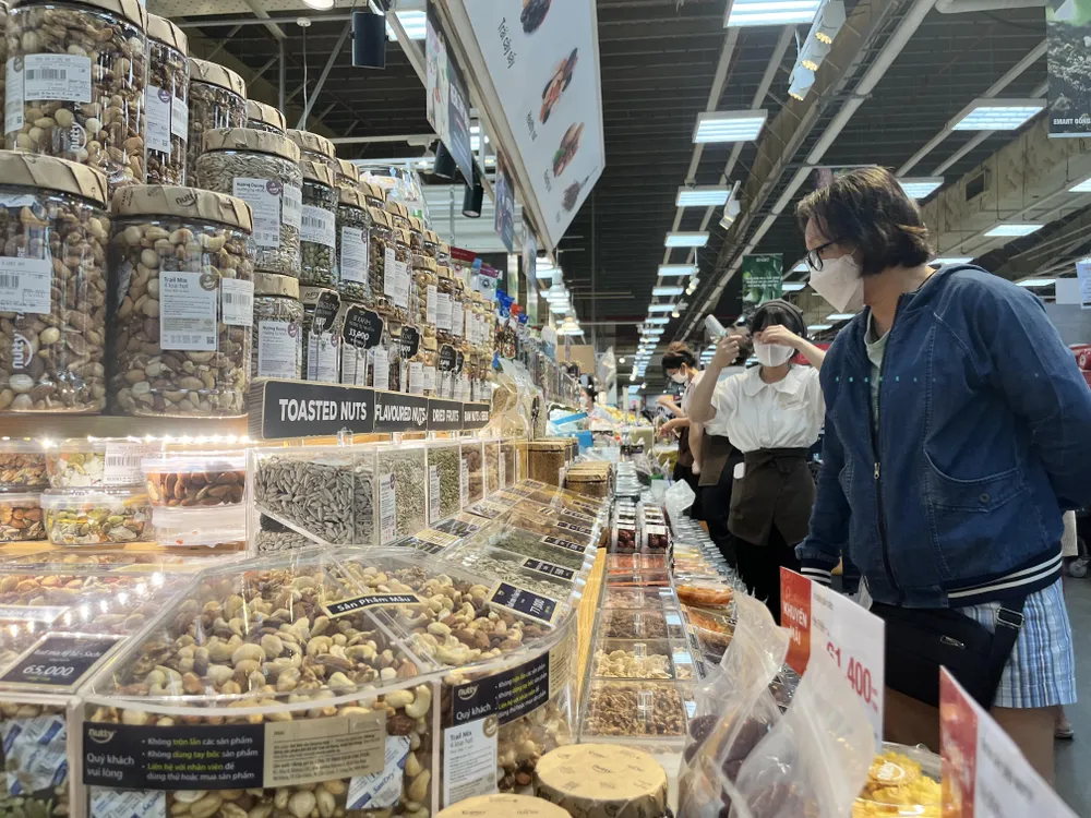 Người tiêu dùng quan tâm đến các loại hạt hướng dương, hạt dẻ...đang khuyến mãi ở siêu thị. Ảnh: TÚ UYÊN Người tiêu dùng quan tâm đến các loại hạt hướng dương, hạt dẻ...đang khuyến mãi ở siêu thị. Ảnh: TÚ UYÊN