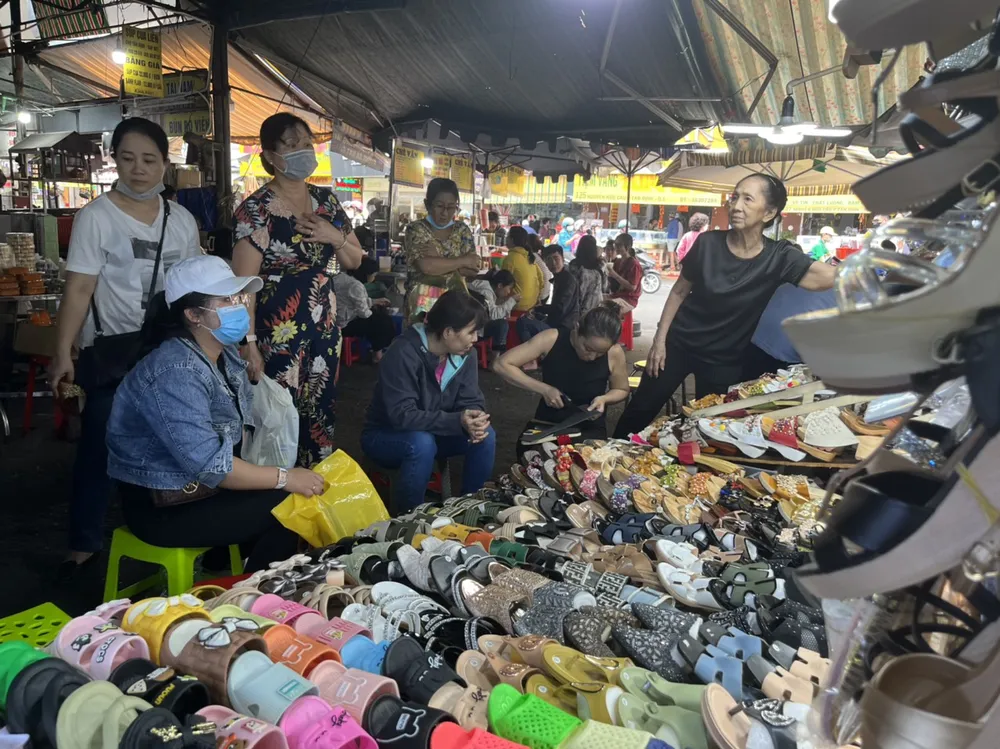 Người dân đi mua sắm dép, guốc.