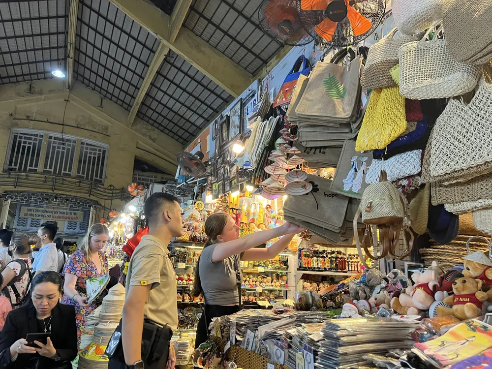 Du khách đang chọn túi xách tại hàng lưu niệm