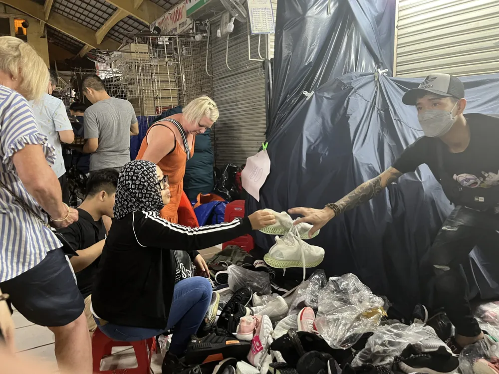 Du khách tranh thủ mua giày đang được giảm giá còn 250.000 đồng/đôi.