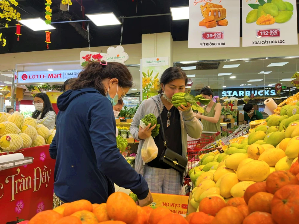 Trái cây như phật thủ, dừa, xoài... trong mâm ngũ quả được người dân chọn mua tại siêu thị trong sáng 13-1