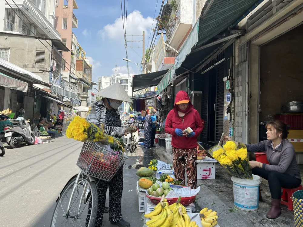 Trưa 23 tháng Chạp tại khu vực chợ Tân Định, quận 1 người dân đi mua hoa chuẩn bị cho ngày cúng ông Táo