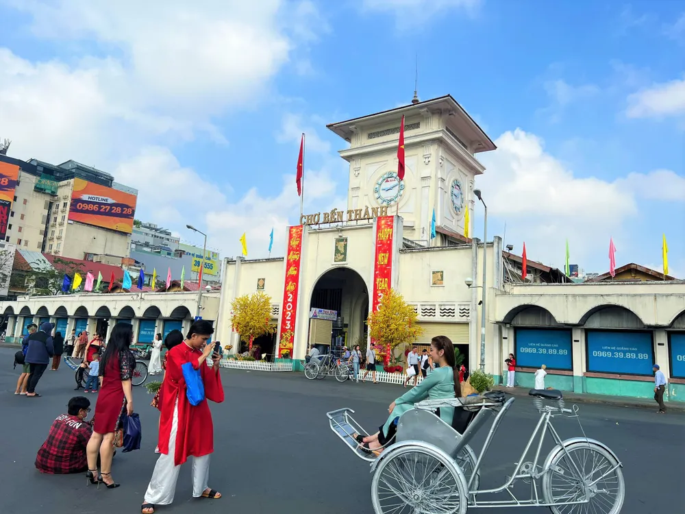 Khu vực trước chợ Bến Thành được phân luồng thông thoáng, người dân đến chụp hình và góp phần thu hút khách tham quan mua sắm. Ảnh chụp sáng ngày 25 tháng Chạp.