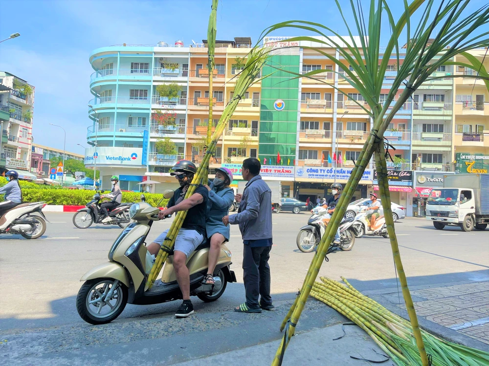 Một người dân cho biết thấy điểm bán này trưng đẹp quá nên mua ba cặp mía về cúng vía Ngọc Hoàng trưa ngày mùng 9 tết